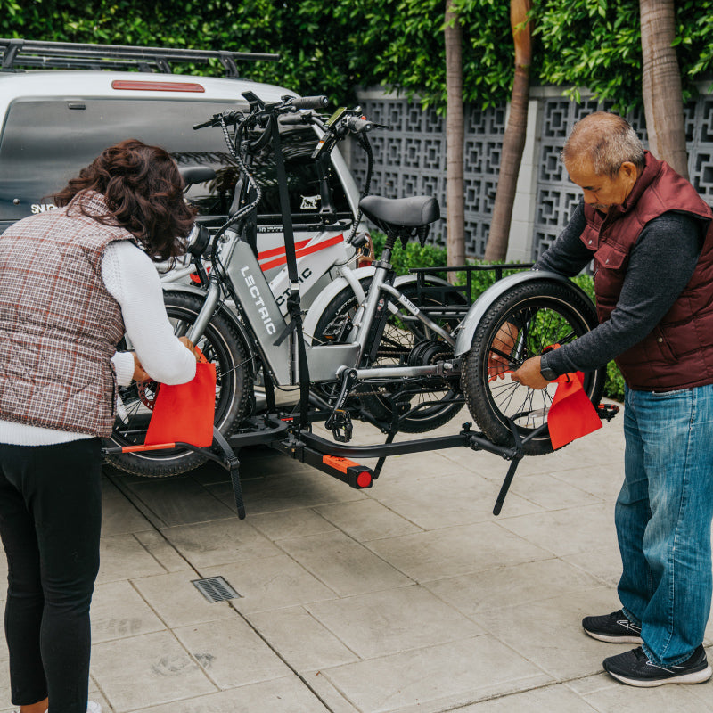 couple montant un Lectric eBikes XP Trike à Hollywood Rack à l’arrière de leur VUS